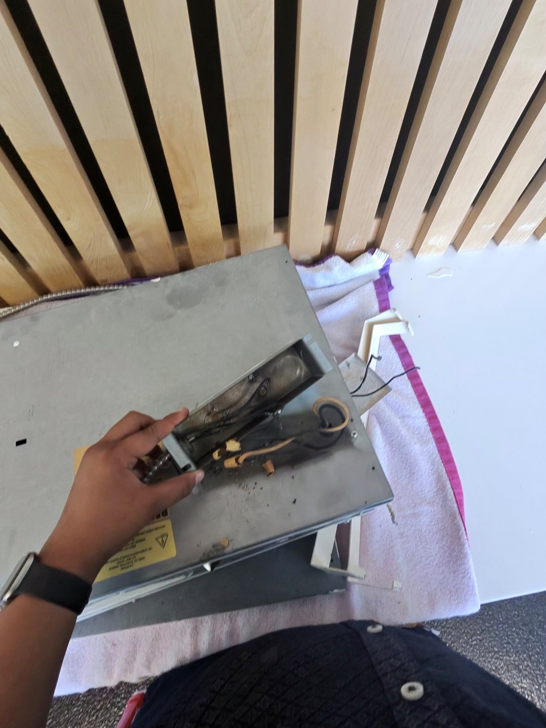 Before repair: damaged wiring and connectors inside an opened heating-panel connection compartment.