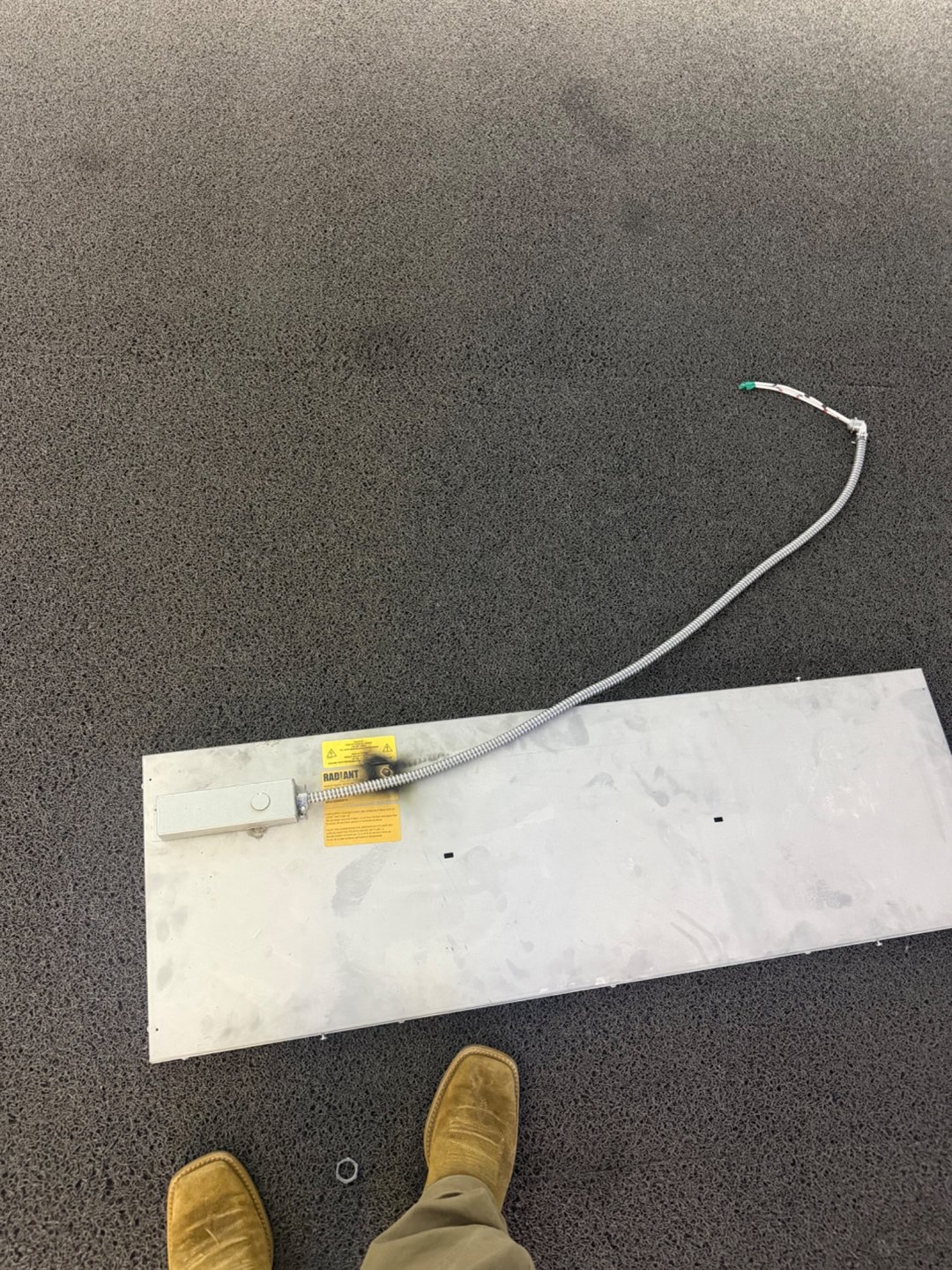 Heating panel removed for service, with its connection cable visible.